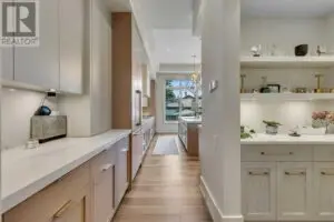 a kitchen with white cabinets and shelves